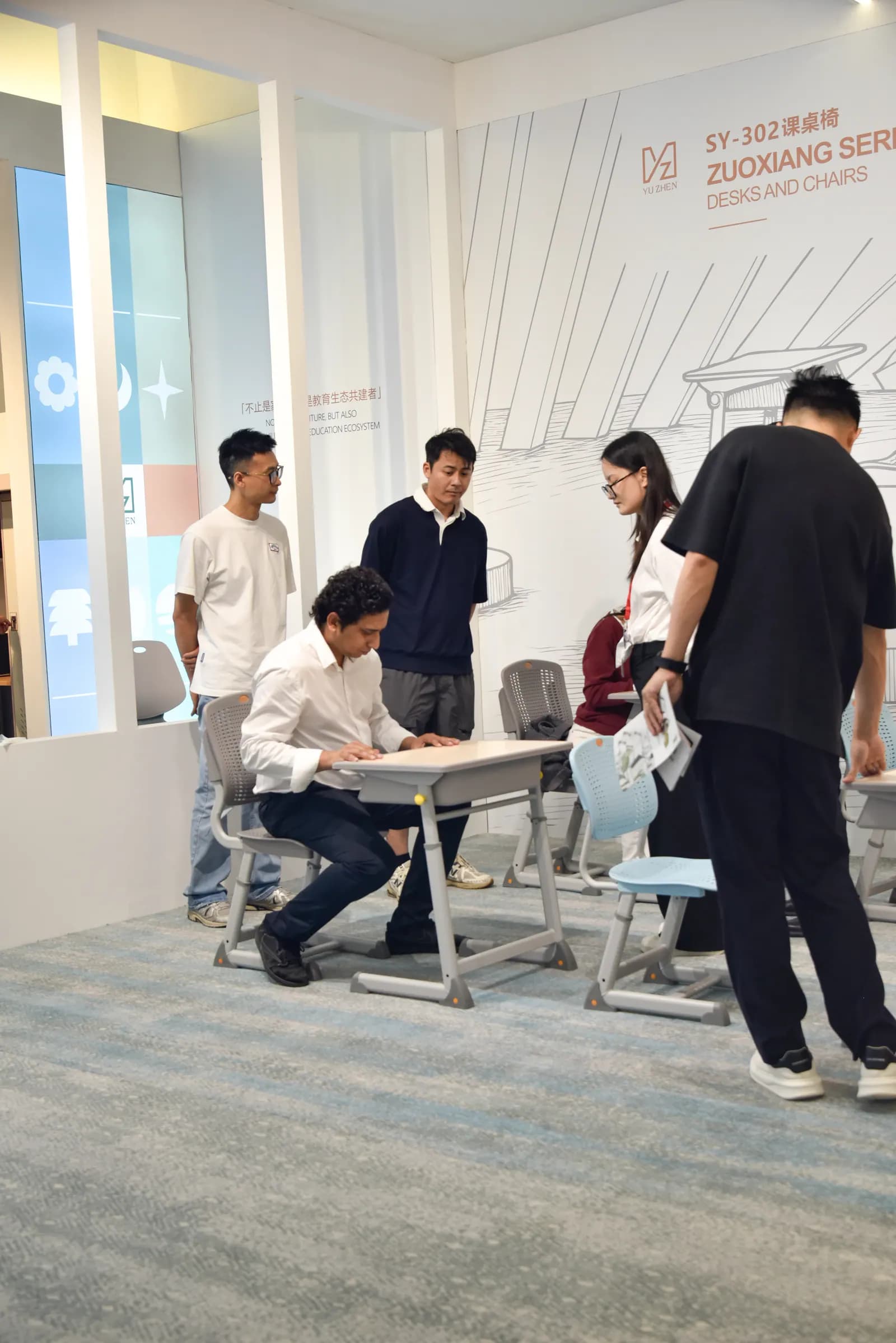 Yuzhen furniture specialist demonstrating a classroom desk and chair solution Yuzhen furniture specialist demonstrating a classroom desk and chair solution